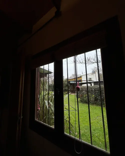 Ventana de la cabaña con vista al césped del parque.