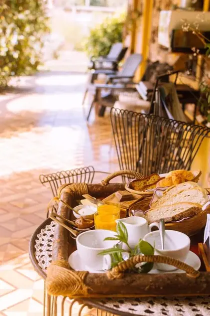 Canasta de desayuno sobre una mesa de la galería, con tazas y pan.