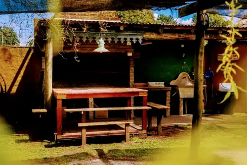 Mesa larga de madera bajo un techo de cañas.
