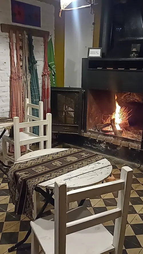 Mesa de madera y sillas junto al hogar, en el comedor.