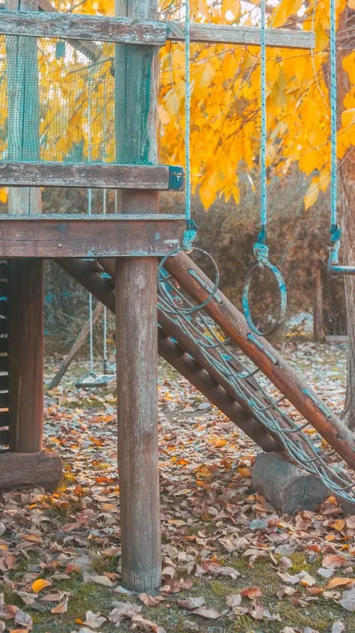 Los juegos de madera para chicos, bajo un árbol en otoño.